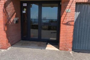 A building entrance with a glass door, a mailbox, and a number '72' sign. - Casa Fannì: Space, Comfort and Breathtaking Views (Varazze)