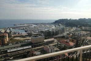 A coastal town with a marina, buildings, and a train track. - Casa Fannì: Space, Comfort and Breathtaking Views (Varazze)
