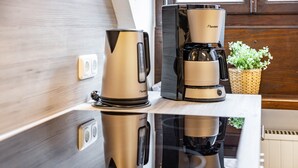 A kitchen with a coffee maker, kettle, and a basket of flowers. - Apartment 'Weitblick' (Top Floor Center) with Free Wi-Fi (max. 6 guests) (Pottenstein)