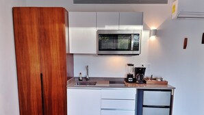 A compact kitchenette with a microwave, a coffee maker, and a refrigerator. - Studio with King Bed in La Veleta (Tulum)
