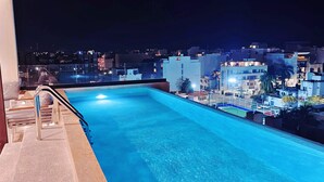 A rooftop pool with a clear view of the cityscape at night. - Centric Studio in 4th Floor with Balcony (Playa del Carmen)