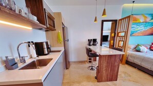 A compact hotel room with a kitchenette, a dining area, and a bed. - Centric Studio in 4th Floor with Balcony (Playa del Carmen)
