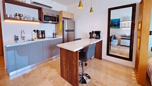A modern kitchen with a central island, stainless steel appliances, and pendant lighting. - Centric Studio in 4th Floor with Balcony (Playa del Carmen)