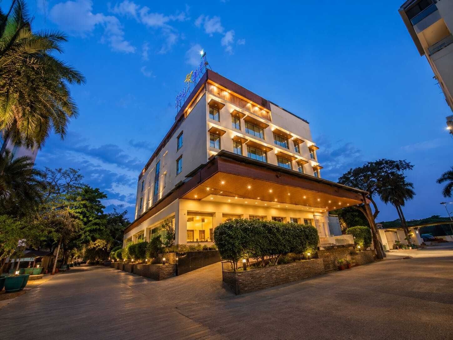 A multi-story hotel with a covered entrance and a well-lit facade.