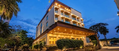 A multi-story hotel with a covered entrance and a well-lit facade.