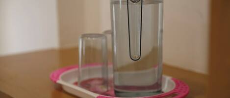 A water filtration pitcher on a pink tray.