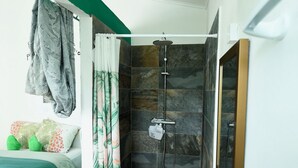 A modern bathroom with a shower, a sink, and a mirror.