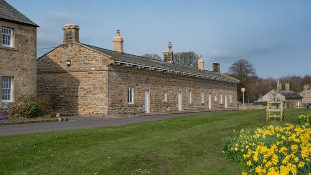 A stone building with a row of windows and a chimney.