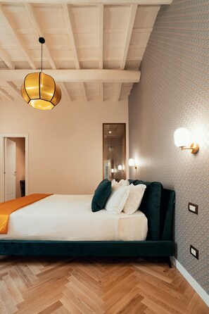 A bedroom with a wooden ceiling, a bed with a green headboard, a white mattress, and a wooden floor. - Casa Mia Navona (Roma)