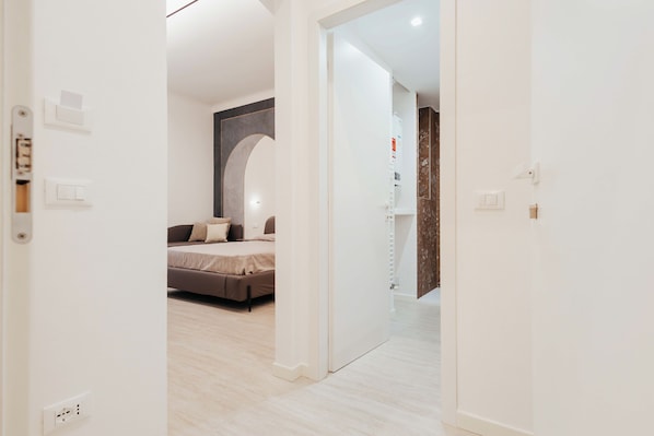 A modern bedroom with a bed, a large mirror, and a wardrobe.