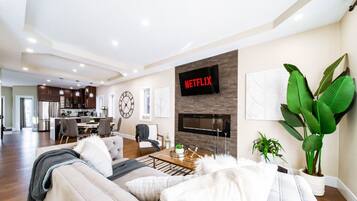 Una sala de estar moderna con un sofá, una mesa de centro y un televisor montado en la pared.