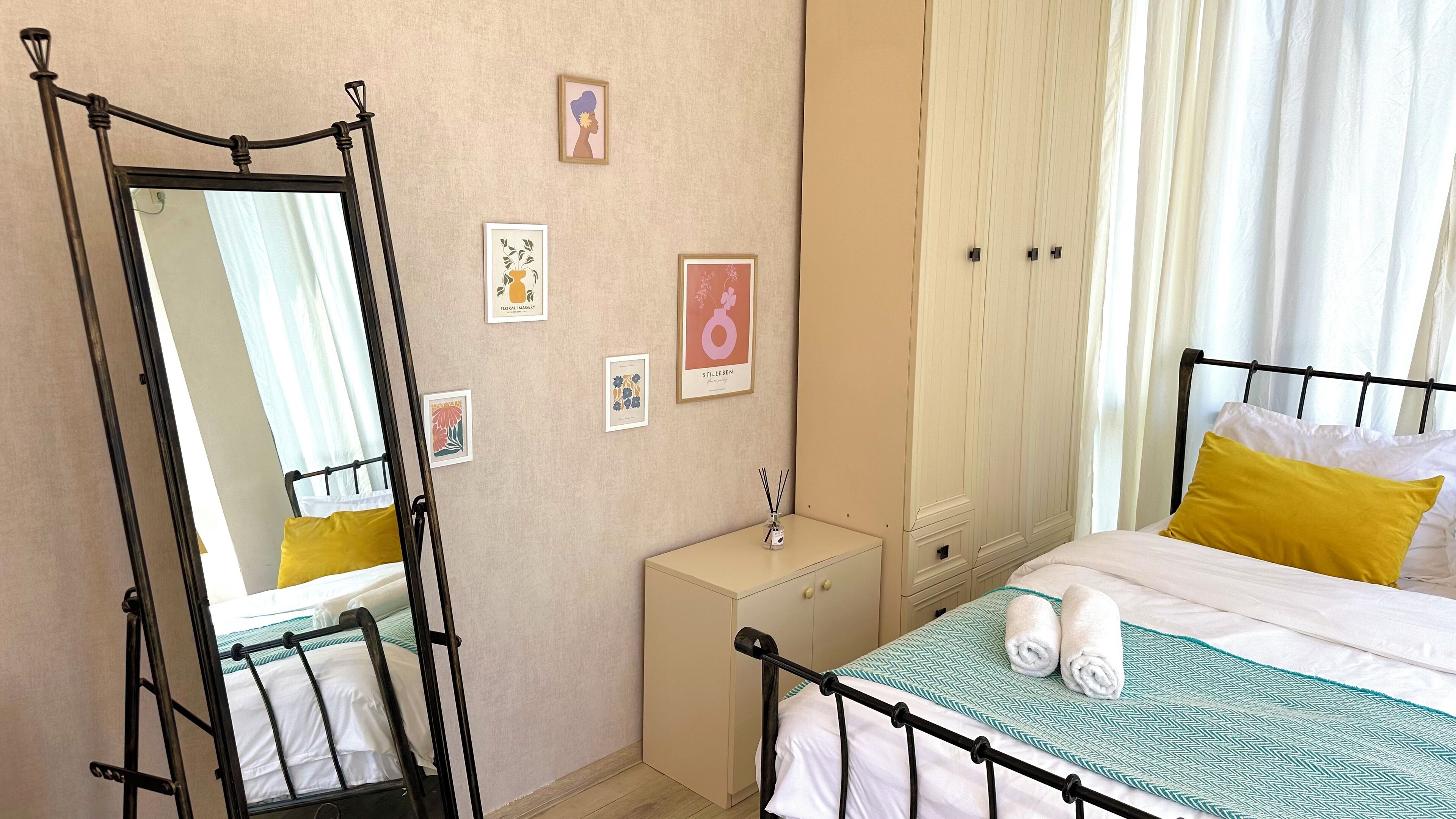 Un dormitorio con cama con dosel, una mesita de noche, un espejo y un armario.