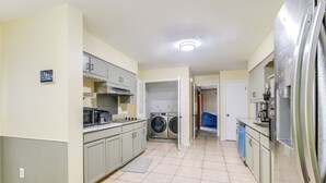 A kitchen with a washing machine, a refrigerator, and a microwave. - 4 BD Family Home w/ Yard & Bbq! in Memphis (Memphis)