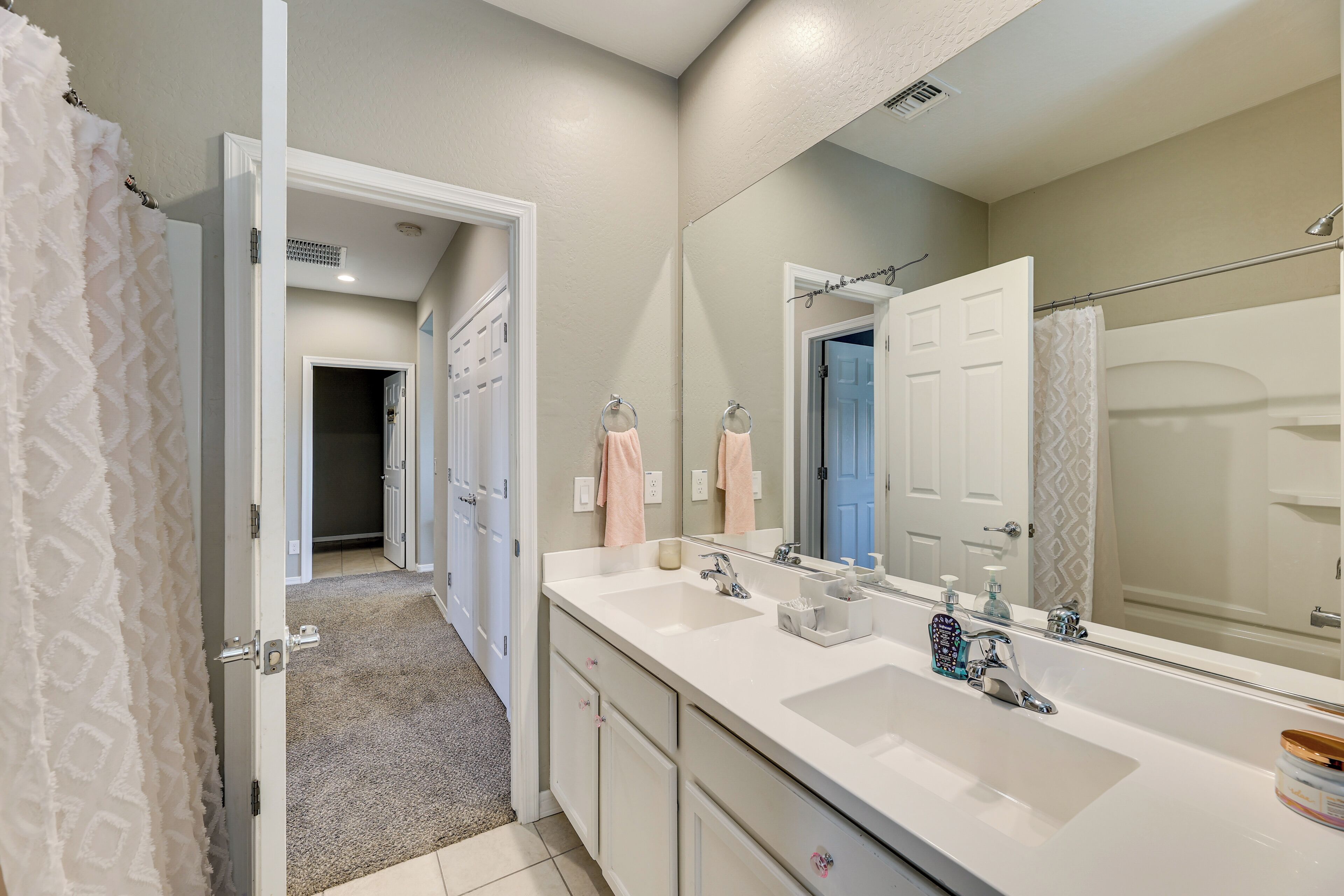 Une salle de bain moderne avec un double vasque, un grand miroir et une douche à l’italienne.