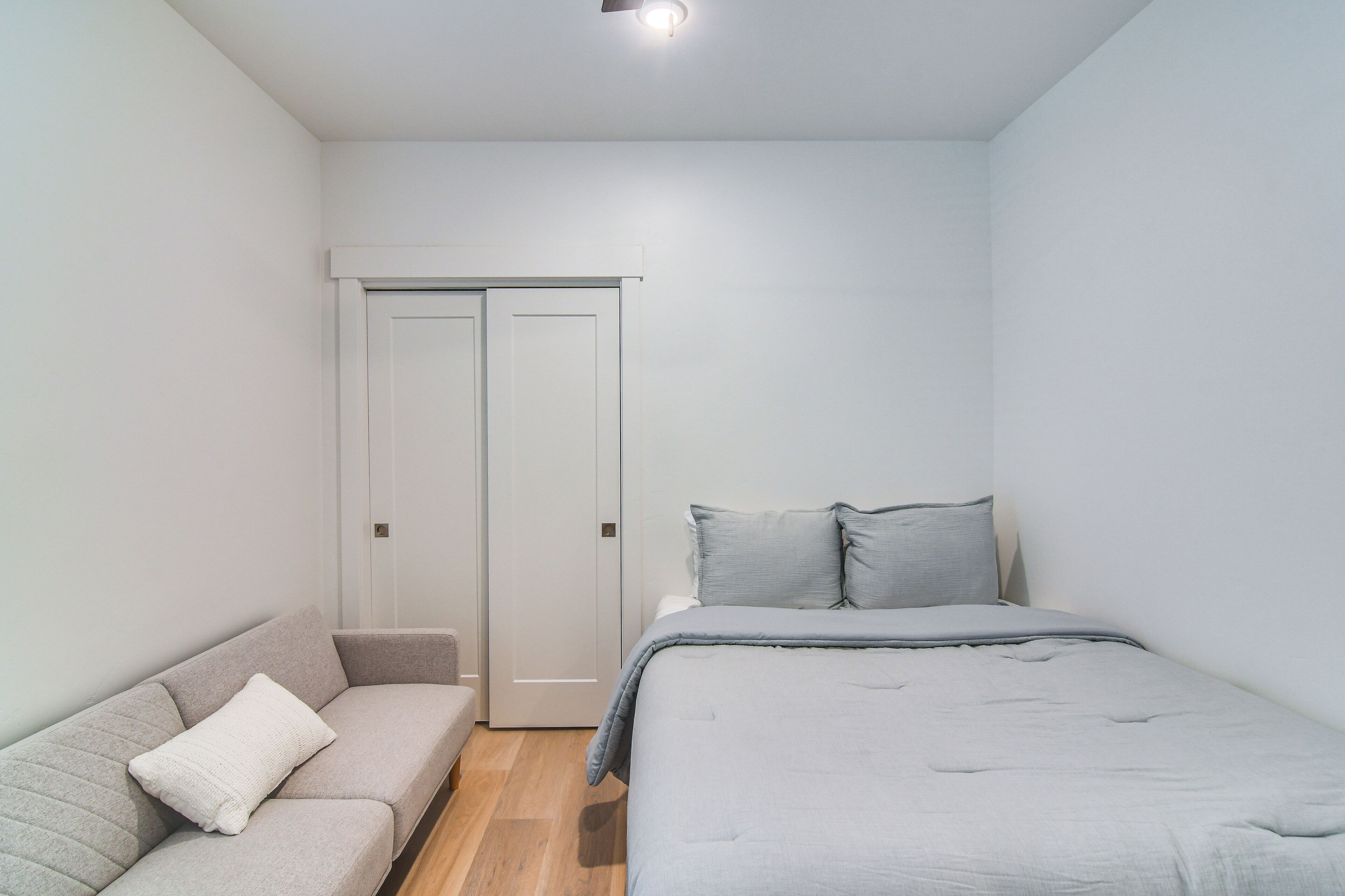 Un dormitorio con cama, sofá y armario.