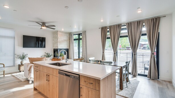 A modern kitchen with a central island, wooden cabinets, and a built-in dishwasher. - 3 Mi to Lake Dillon: Condo Near Shops & Eats! (Silverthorne)