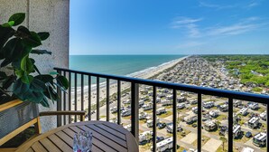 Un balcon avec vue sur la plage et le parking pour les camping-cars.