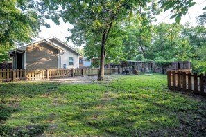 A residential property with a detached house, fenced yard, and a covered outdoor area. - Hot Tub + Outdoor Kitchen: Stylish Home in Bryan (Bryan)