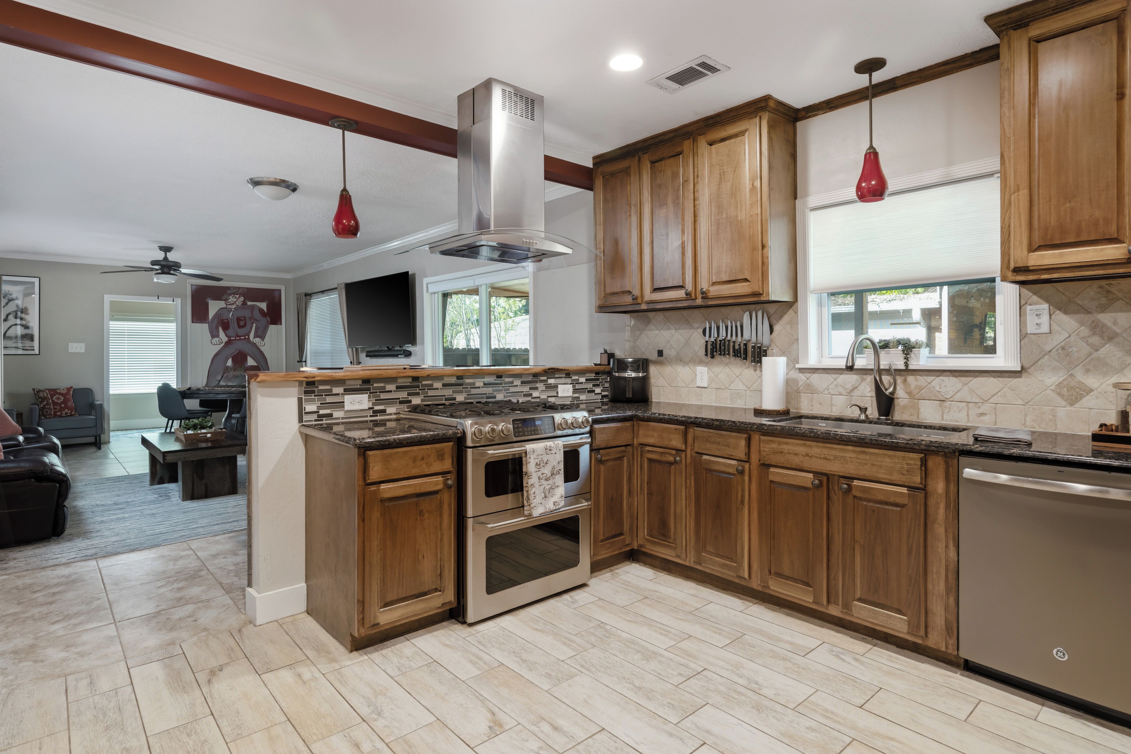 Una cocina moderna con armarios de madera, electrodomésticos de acero inoxidable y una isla central.