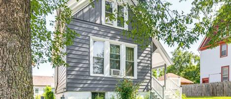 A two-story house with a front porch, a visible staircase, and a well-maintained lawn.