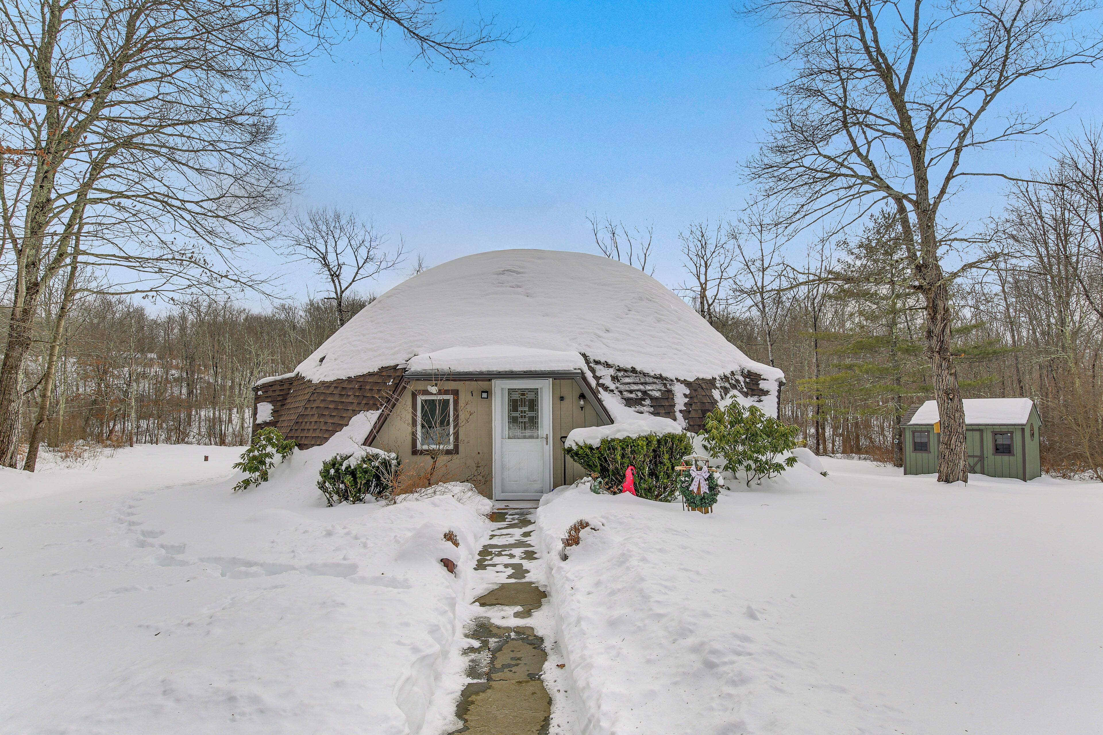 Una casa cubierta de nieve con un sendero que lleva a la puerta.