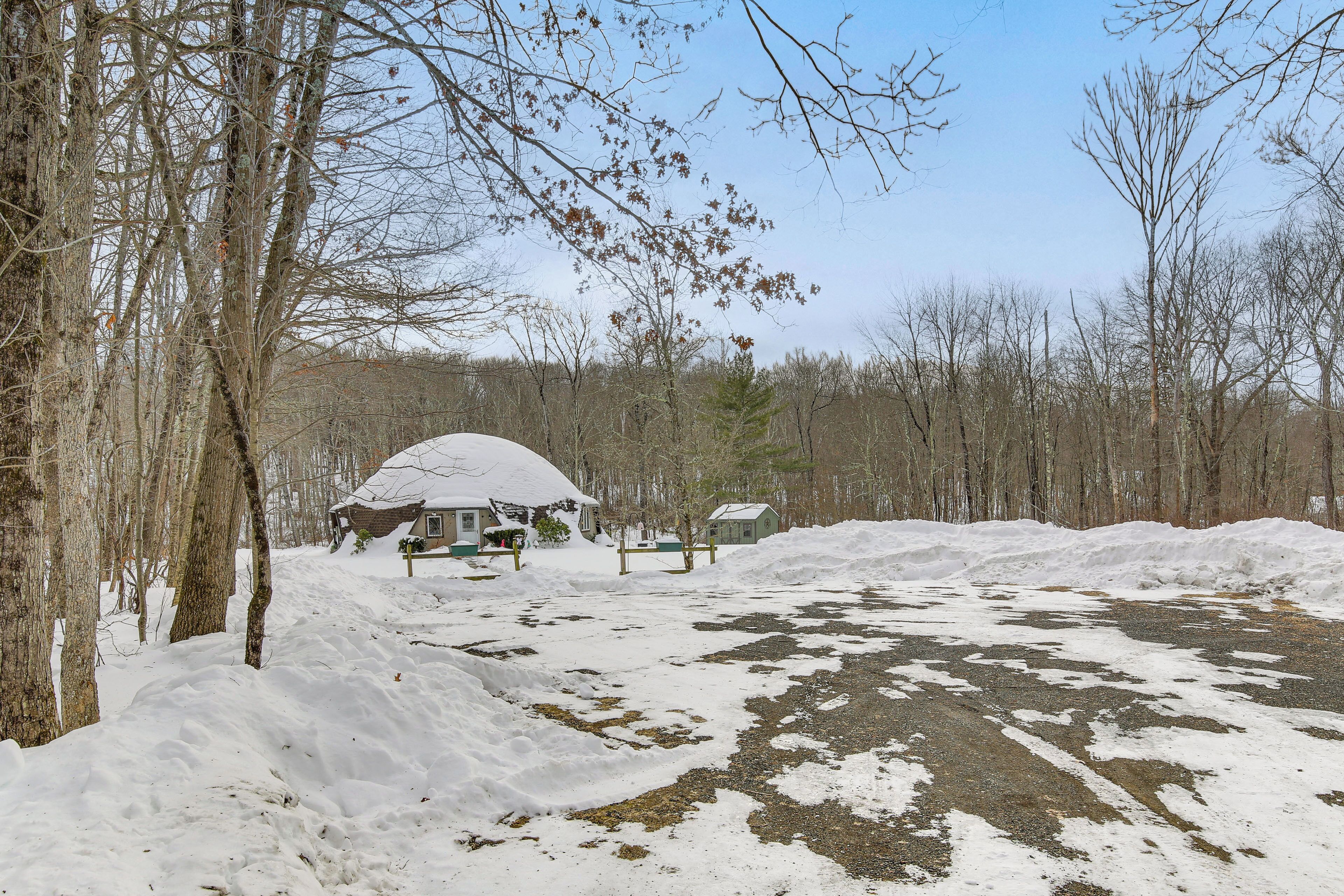 A snow-covered landscape with a cabin and a large pile of snow.
