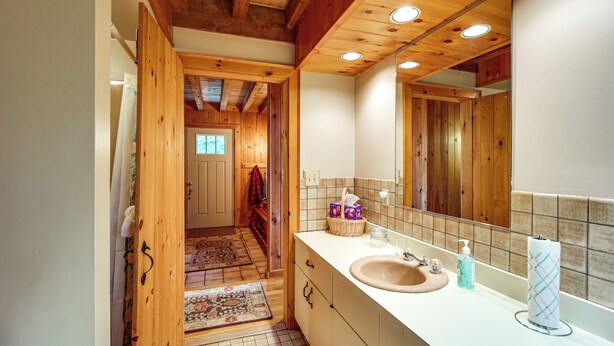 A wooden interior bathroom with a sink, mirror, and a small window. - 8 Mi to Okemo Mountain Resort: Mtn-view Retreat! (Ludlow)