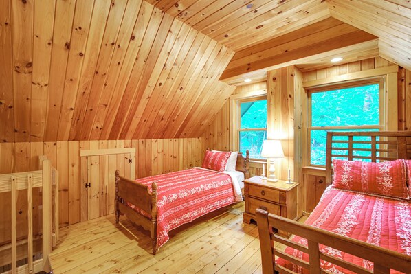 A wooden cabin bedroom with two beds, a nightstand, and a window. - 8 Mi to Okemo Mountain Resort: Mtn-view Retreat! (Ludlow)