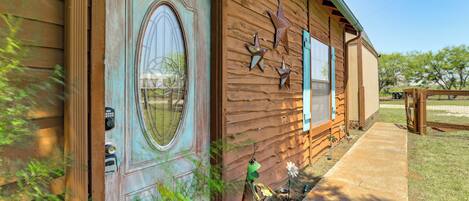 Un bâtiment rustique en bois, doté d’une grande porte décorative, d’un petit porche et surplombant un ciel dégagé.