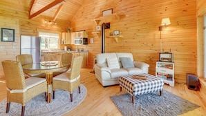 A cozy cabin interior with a dining area, a sofa, a television, and a kitchen. - Bluff Views: 'bunker Hill' Cabin in Mindoro! (Mindoro)