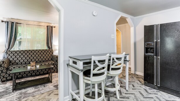 A compact kitchen with a dining area, a black refrigerator, and a patterned sofa. - 14 Mi to Downtown Baton Rouge: Plaquemine Retreat (Plaquemine)