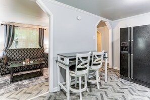 A compact kitchen with a dining area, a black refrigerator, and a patterned sofa. - 14 Mi to Downtown Baton Rouge: Plaquemine Retreat (Plaquemine)