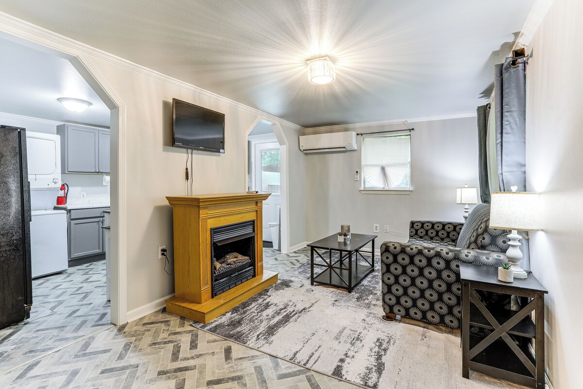 A living room with a fireplace, a sofa, a coffee table, and a TV mounted on the wall.