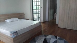 Un dormitorio con una cama de madera, un tapete redondo y un armario.