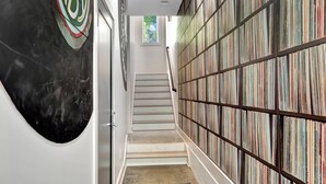 A staircase leading to a room with a bookshelf filled with books. - Rooftop Deck 2 Car Garage Near Downtown Nashville (Nashville)