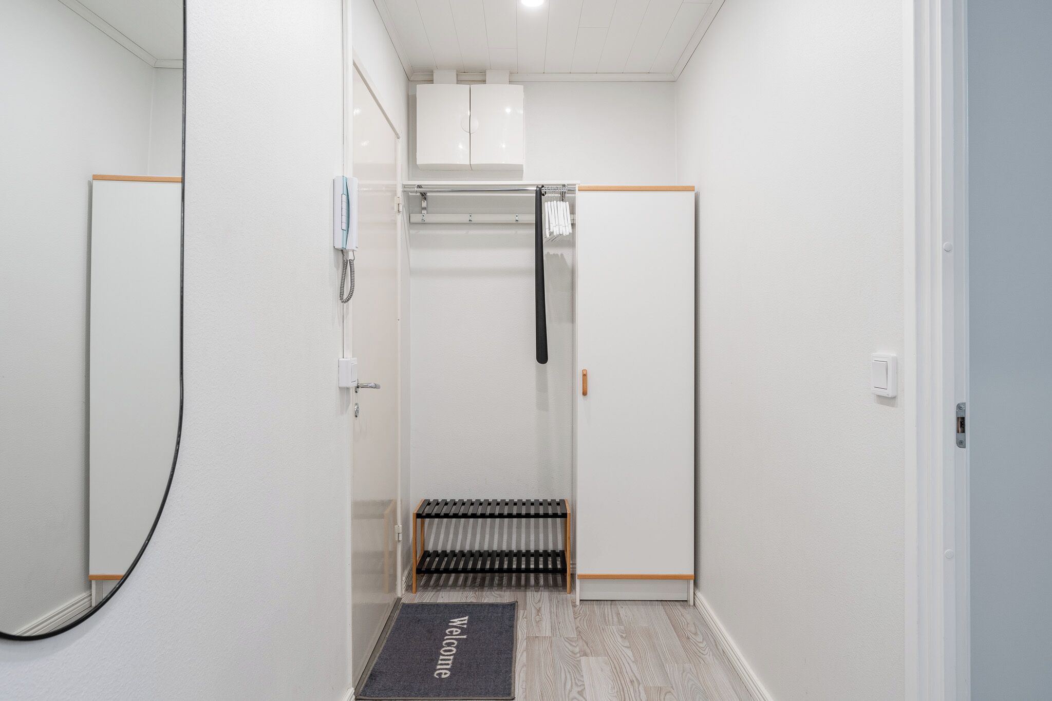 A narrow hallway with a radiator, a towel rack, and a door with a handle.