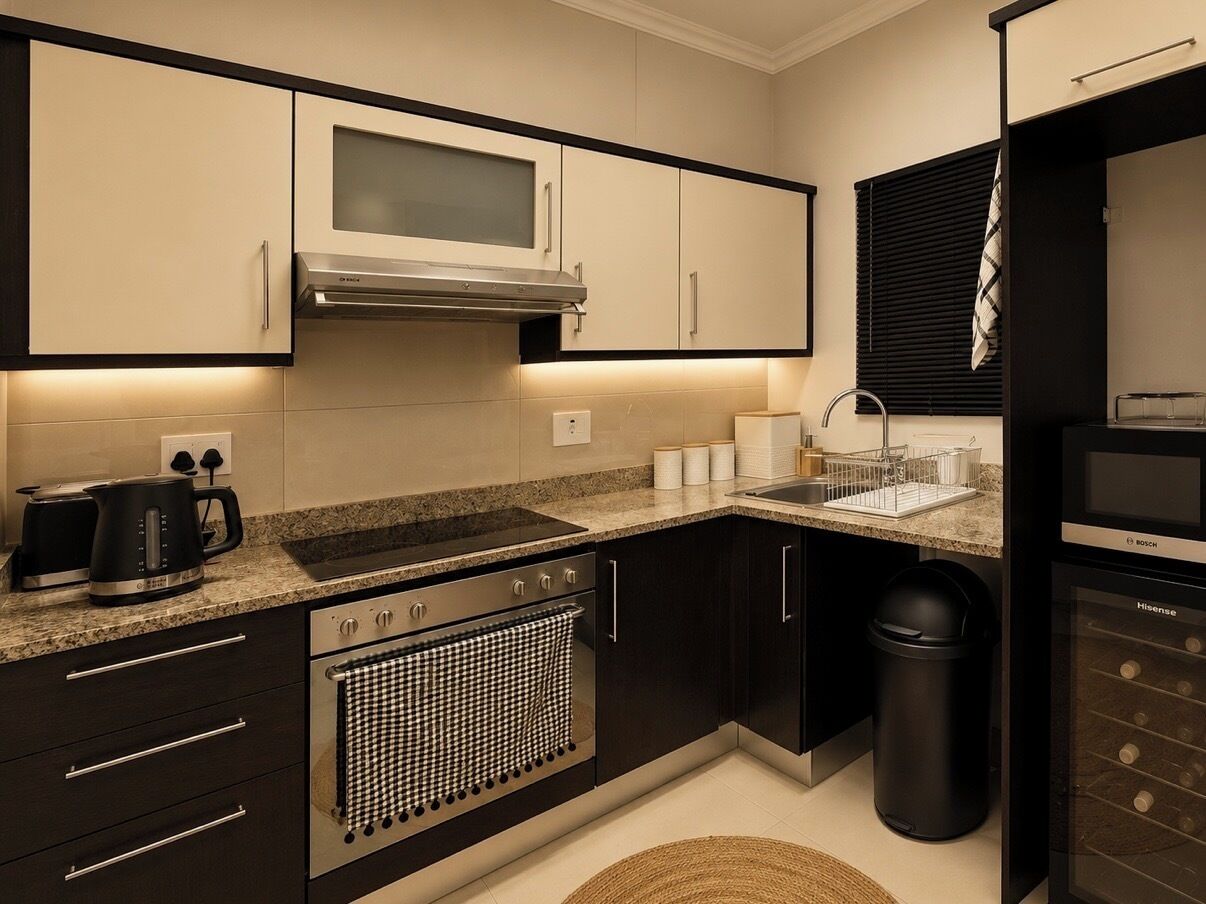 Una cocina moderna con microondas, estufa, pileta y un refrigerador Bosch.