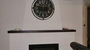A fireplace with a clock above it. - Blue room 4 persons (Poyanne)
