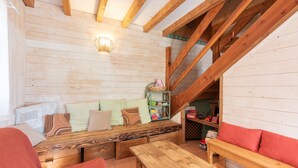A cozy wooden interior with a bench seating area, a table, and a staircase.