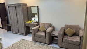 Uma sala de estar moderna com dois poltronas, um espelho grande e um guarda-roupa.
