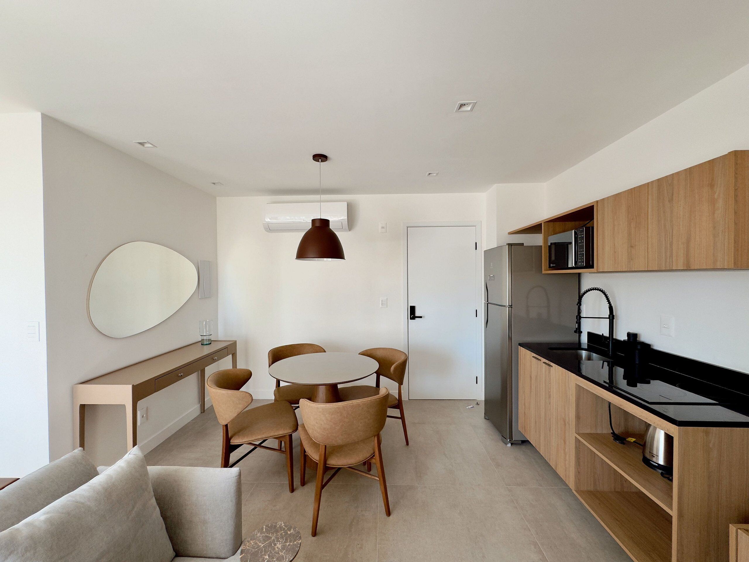 Une cuisine moderne dotée d’un îlot central, de meubles en bois et d’un réfrigérateur en acier inoxydable.