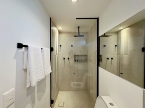 A modern bathroom with a walk-in shower, a large mirror, and a towel rack. - Homm Pinheiros (Sao Paulo)
