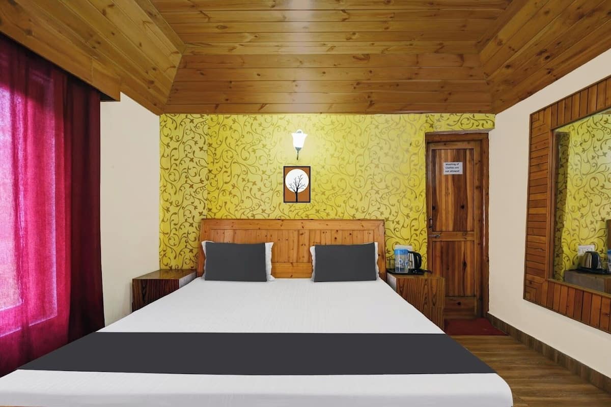 Un dormitorio con techo de madera, una cama con dos almohadas, una mesita de noche, un espejo y una puerta con un cartel.