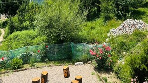 A residential area with houses, a garden with flowers, and a mountainous backdrop.