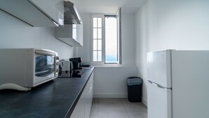 A kitchen with a microwave, toaster, and a window with a view.