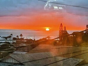 Tramonto su una zona costiera con un ponte e degli edifici in primo piano.