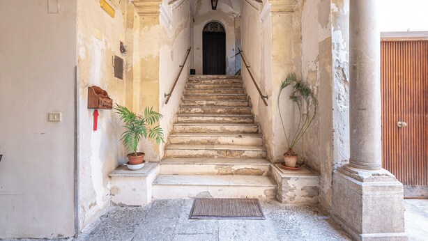 A staircase leading to a door with a sign reading "POSTA". - Real Umberto Apartments by Wonderful Italy (Palermo)