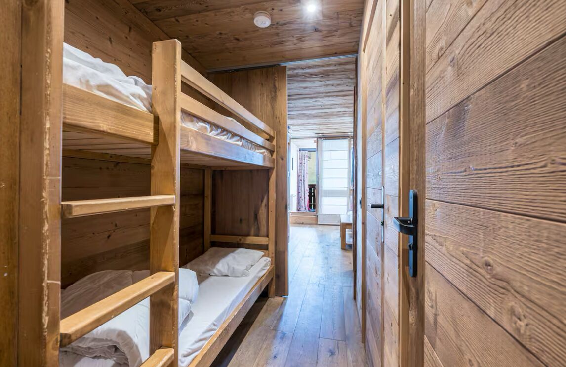 Un intérieur en bois avec des lits superposés et une porte.