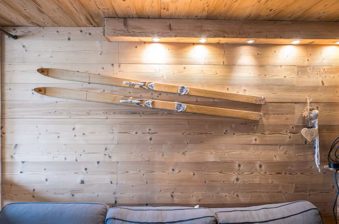 Een houten wand met ski's en een decoratie in de vorm van een hart.