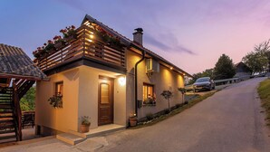 Una casa acogedora con un balcón de madera, una puerta principal y plantas en macetas.